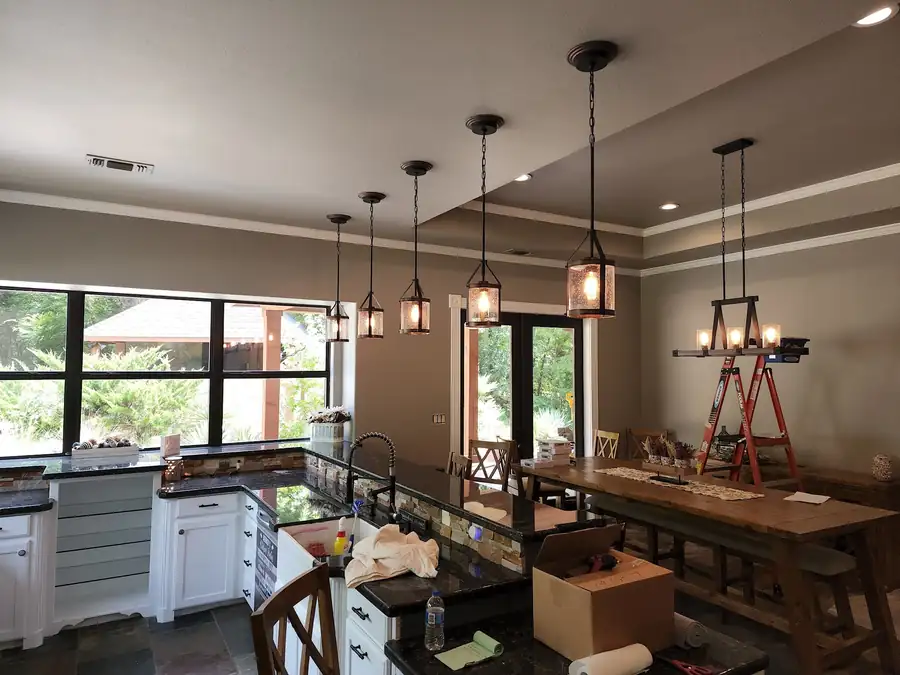 Lantern pendants and an iron linear chandelier over a long dining table