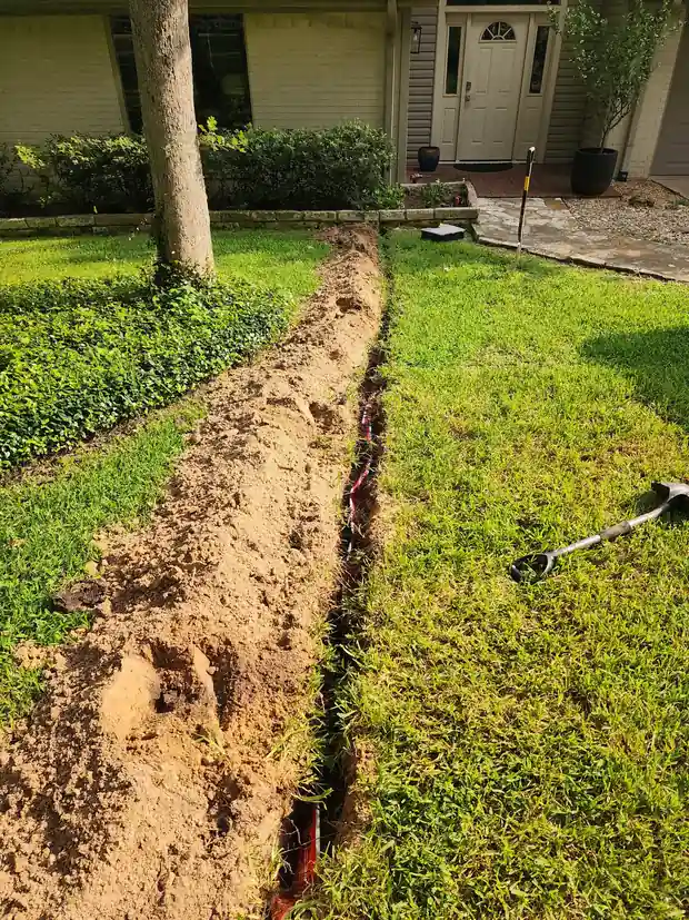 Fresh trench across a front lawn for an underground electrical run