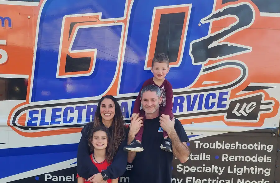 Justin Zimmerman with his family in front of the GO 2 Electrical Service truck wrap