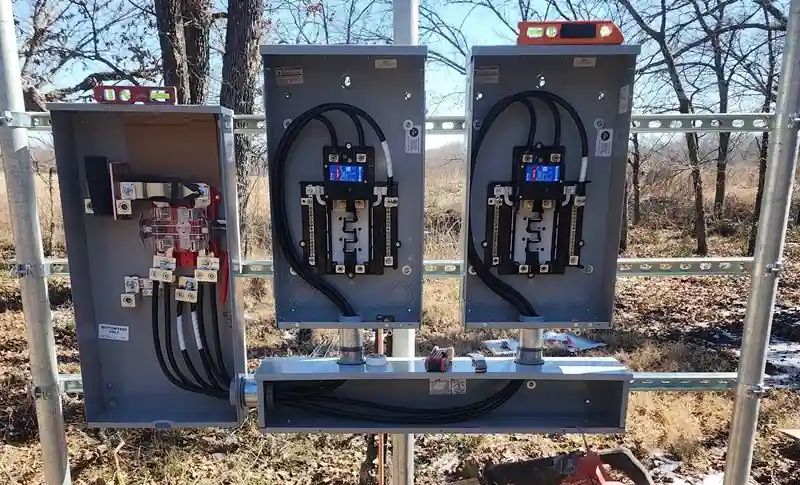 Three meter and panel enclosures on a galvanized strut rack in an open field
