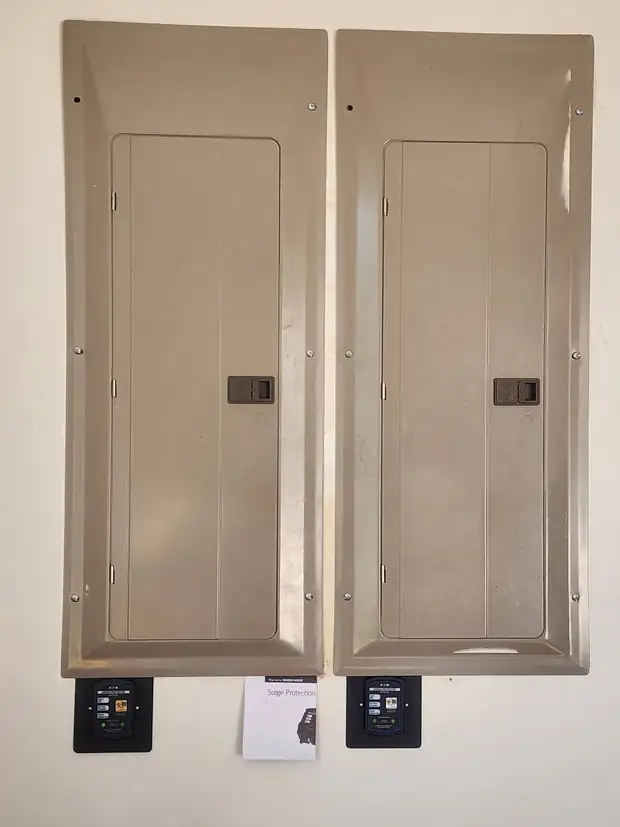 Two flush panels side by side, each with a surge protector display below
