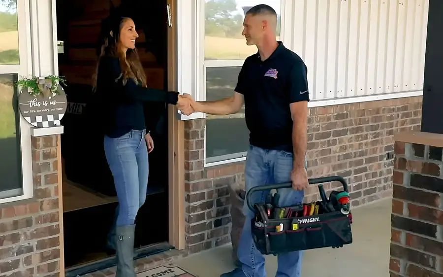 Justin with his tool bag shaking hands with a homeowner at the front door